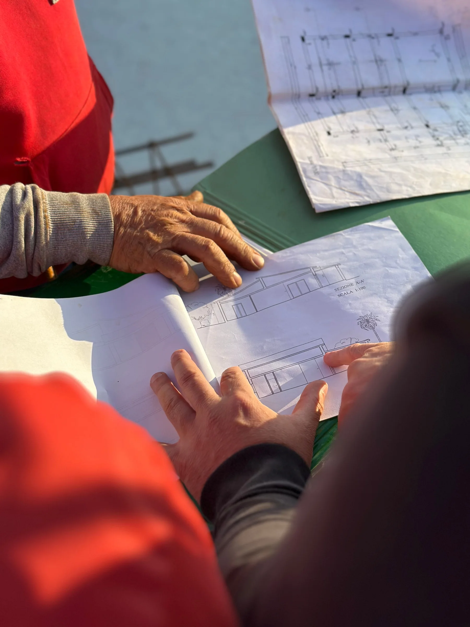 Two people reviewing architectural plans together at a property.