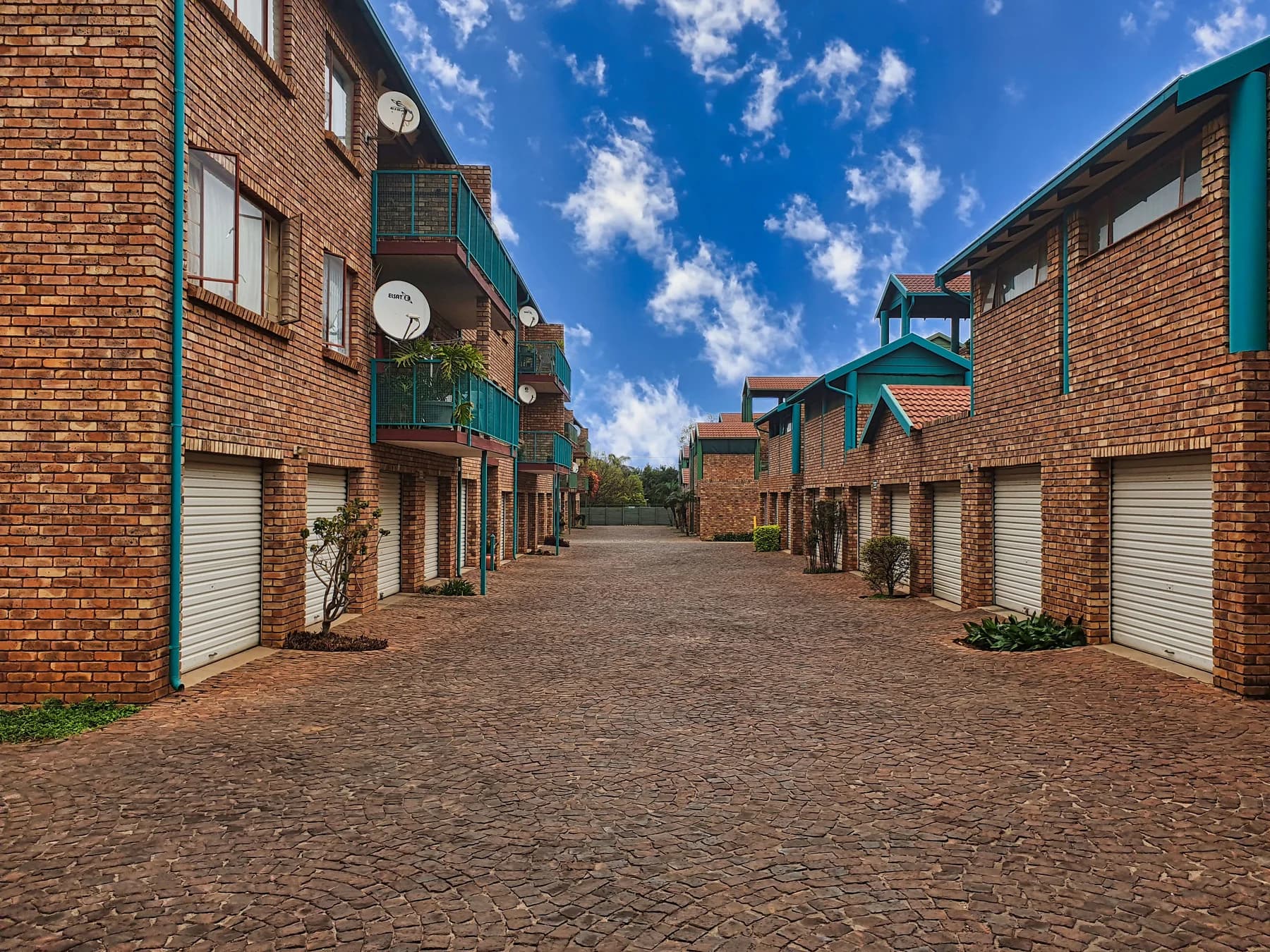Courtyard view of a maintained brick multifamily complex under a clear sky.